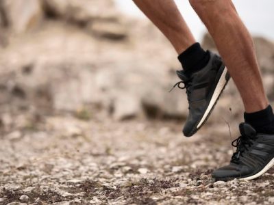 Gros plan sur les pieds et les chaussures d un coureur progressant sur un sentier caillouteux en nature