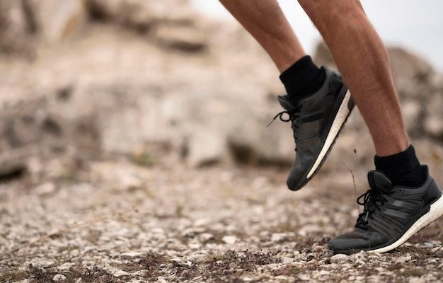 Gros plan sur les pieds et les chaussures d un coureur progressant sur un sentier caillouteux en nature